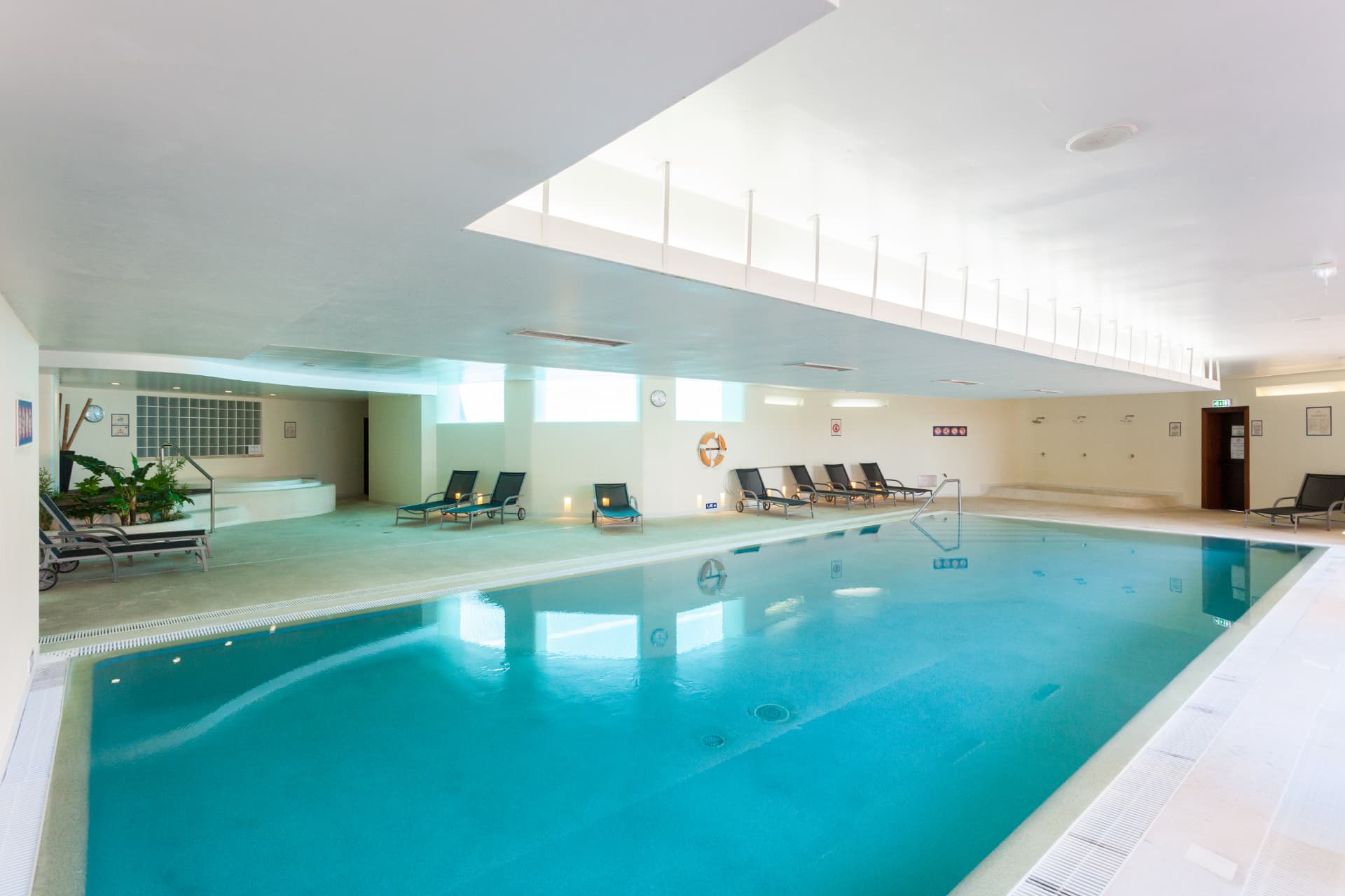 The resort's indoor pool with loungers, jacuzzi and skylight above