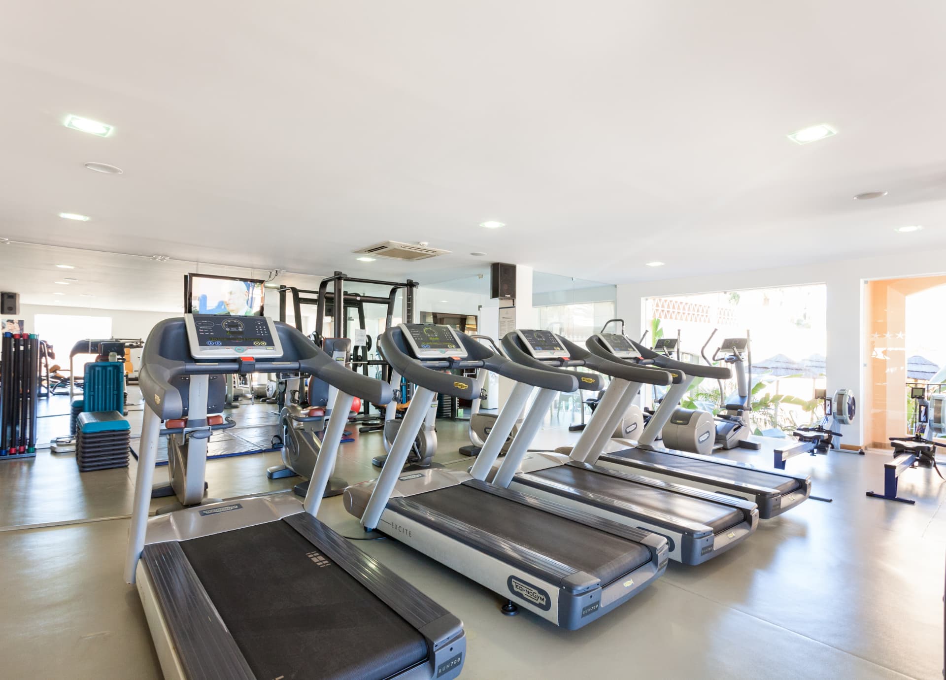 The resort gym with treadmills, weights and daylight from the terrace