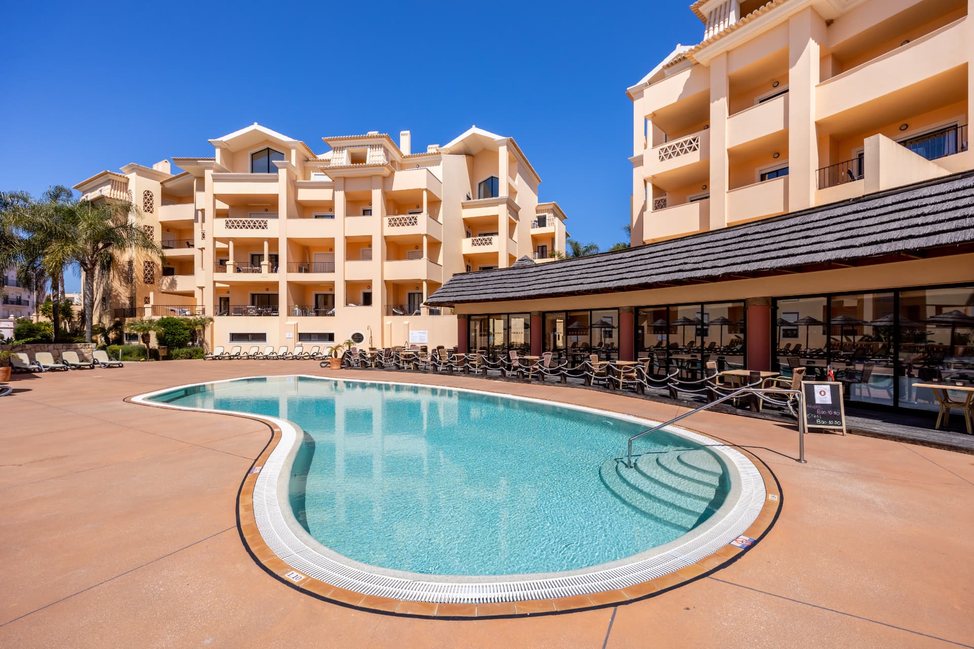 The main outdoor pool at Estrela da Luz, framed by the resort's apartment buildings and poolside terrace
